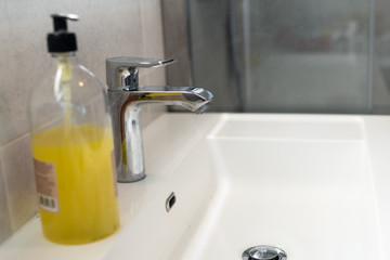 basin sink in a bathroom and liquid soap dispenser