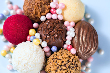 Chocolate round candies decorated with sugar sprinkles, various sweets close-up