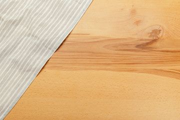 Top view on a wooden table with a linen kitchen towel or textile napkin.