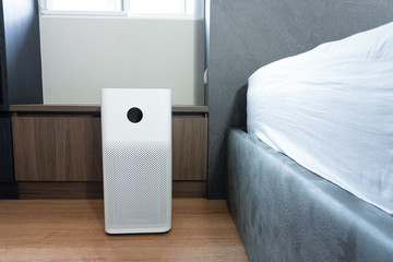 Indoor air purifier with digital monitor screen in bedroom locate side bed, that show air quality in the room. PM 2.5 is a major environmental health problem affecting everyone.