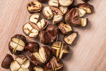 Roasted chestnuts scattered on a wooden surface