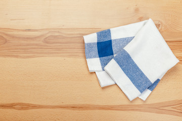 Top view on a wooden table with a linen kitchen towel or textile napkin.