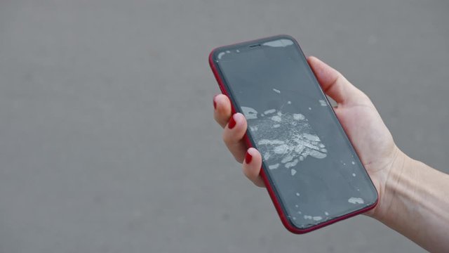 Female hand holding a broken phone, close-up