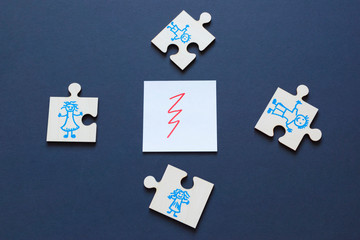 Unhappy family concept, crack and people drawn on puzzles on the dark background.