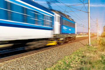 Obraz premium train going to a stop opposite the sun