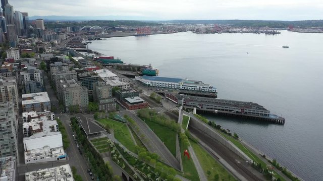 Aerial / drone footage of the Elliott Bay and Puget Sound, Seattle waterfront, Alaskan Way without people downtown, in the commercial district of Seattle, Washington during the pandemic