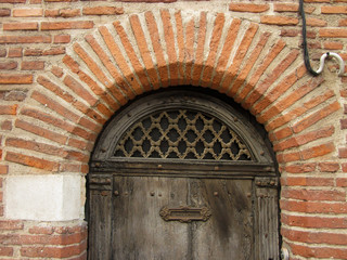 Detail of wooden door with arch of brick in the old city center of Albi. France. 