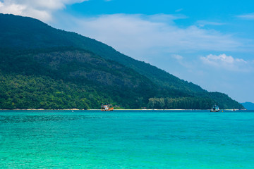 Long tail boat on the sea at Ko Lipe island, Thailand. Tropical island with white sand, beach and turquoise sea is part of Tarutao National Marine Park. Idyllic vacation, relaxation in paradise.