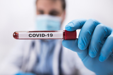 Man doctor with covid-19 blood test in hands