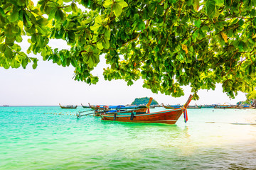 Long tail boats in small harbor at Ko Lipe island, south Thailand. Tropic and exotic island is symbol of tropical paradise, part of Tarutao national nature park. Vibrant colors, turquoise water.