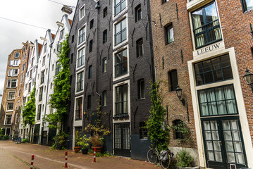 Fototapeta na wymiar Classic narrow street and traditional Dutch architecture colorful houses in downtown Amsterdam, Netherlands