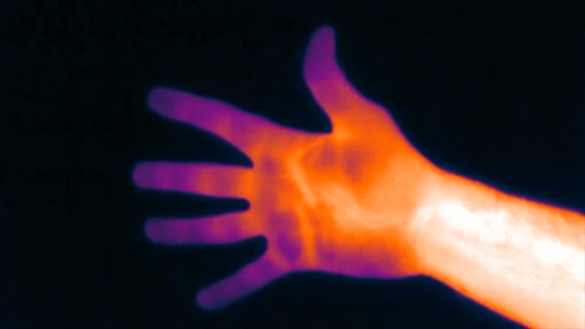 ultra violet spectrum Thermal imaging camera detecting hand temperature. Hand count to five then left a thermo mark on the wall. Thermography concept.