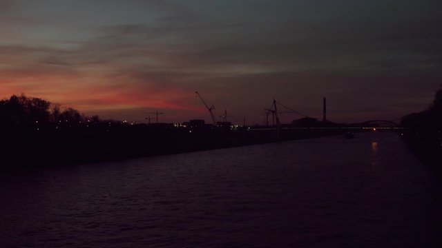 Drone of Red sunset Amsterdam-Rhine Canal At Night With Daphne Schippers Bridge - Busiest Freight Ship Canal In The World Now Nearly Empty Due To Coronavirus In Netherlands. - aerial shot