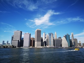 Fototapeta premium The Lower Manhattan skyline in New York City seen from the ocean on a sunny day