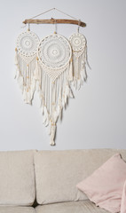 Three beautiful white dream catcher on the light color wall. Boho handmade style decor.