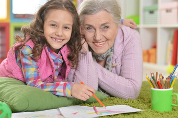 Fototapeta premium Portrait of grandmother and granddaughter drawing together