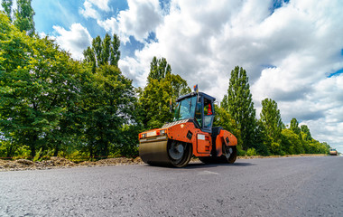 Industrial pavement truck. Laying fresh asphalt on construction site. Heavy machine industry. Mechanical engineering.