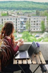 Girl looking at people on the street from her balcony during covid19 quarantine
