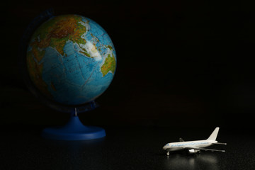  travel concept.  airplane on a dark background on a background of the globe. flight to any point of the world.