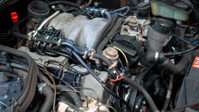 Car repair shop - engine under the car hood. Automobile car engine bay in garage industry