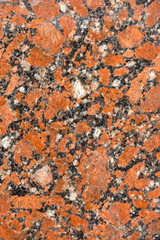 natural drawing of granite surface with rich red hue, coarse-grained structure with small inclusions of various shades