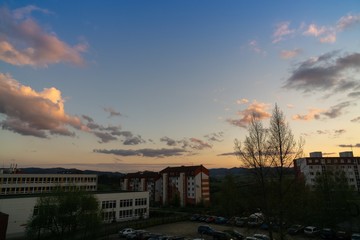 Sunrise and sunset, beautiful clouds over the meadow, hills and buildings in the town. Slovakia