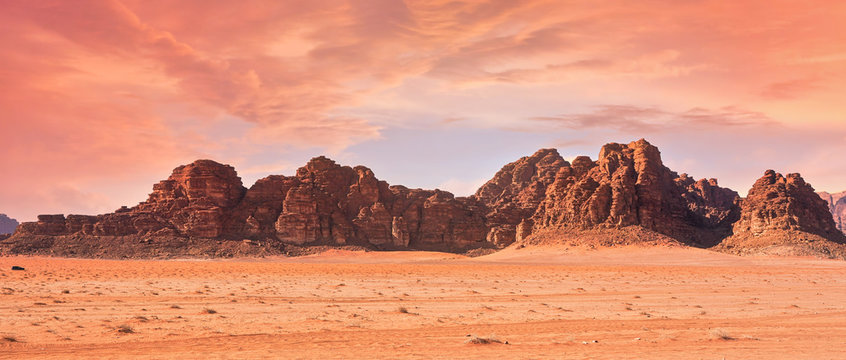 Planet Mars like landscape - Photo of Wadi Rum desert in Jordan with red pink sky above, this location was used as set for many science fiction movies