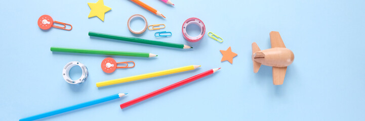 Stationery colorful writing tools accessories pens pencils, color paper on blue background