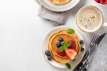 Delicious pancakes with berries and coffee