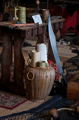 Pirate still life scene with old maps rolled up, muskets, knife and other objects.