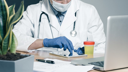 A doctor testing urine sample. Fresh specimen in a cup for examining.