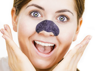 Woman applying pore strips on nose