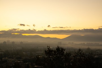 Sunrise and sunset, beautiful clouds over the meadow, hills and buildings in the town. Slovakia