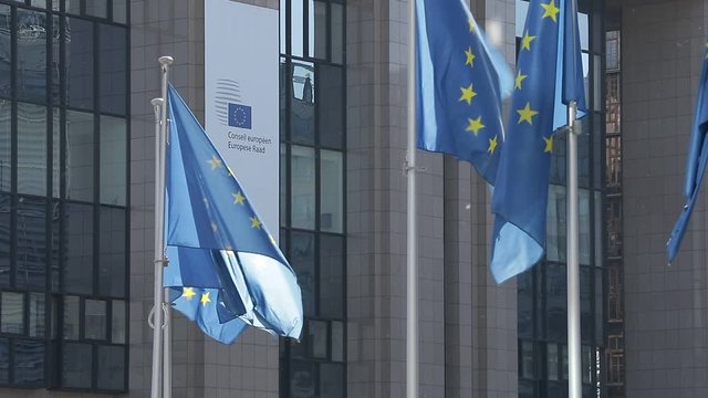BRUSSELS, Belgium -May 6, 2020:
European flags blowing in front of the seat of the Council of the European Union.