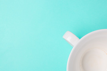 White cup on a blue background with copyspace. Top view.