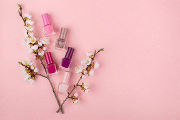 Nail Polish on a pink background. Manicure set with Sakura flowers flat lay. Close up с пространством для текста.