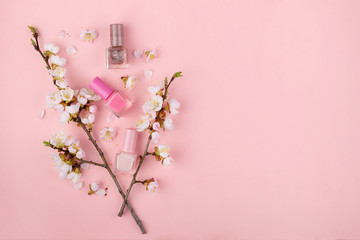 Nail Polish on a pink background. Manicure set with Sakura flowers flat lay. Close up с пространством для текста.
