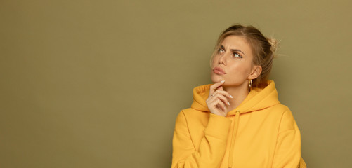 Image of a dreaming pleased young pretty woman posing isolated over green background.