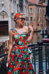 Naklejka premium elegant, fashionable girl with glasses stay on the steps of the bridge, in a romantic Venice,Italy