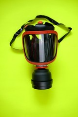 Protective mask with filter. safety mask with a respirator on bright yellow neon background.Coronavirus protection.antivirus mask concept.