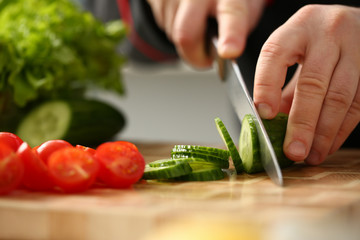 Cook holds knife in hand and cuts on