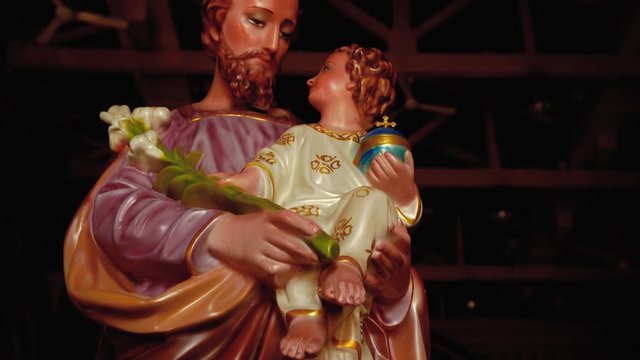 The statue of a saint is helping children that adorn the church.
