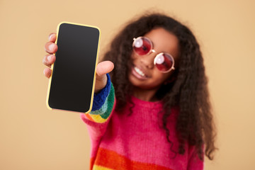 Ethnic child showing modern smartphone