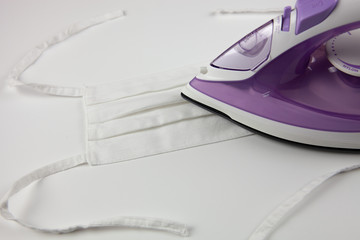 Reusable protective mask. Disinfection of the mask with a hot iron. Life during the epidemic. COVID-19v