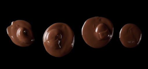 Spilled chocolate cream spread isolated on black background, top view