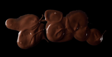 Spilled chocolate cream spread isolated on black background, top view