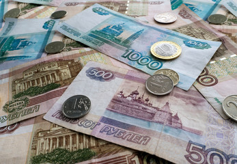 Fototapeta na wymiar Russian money fills the whole background. Paper and metal rubles are visible in perspective.