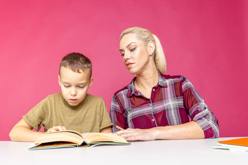 Homeschooling and distance education for students. Little child boy learn with mum at home school. Boy student doing homework helped by his mother.