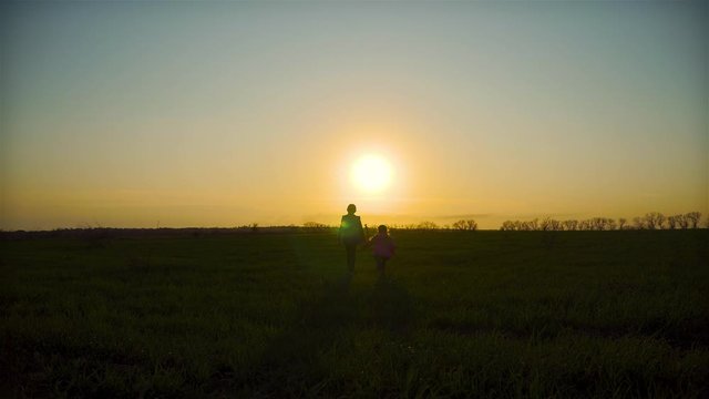 Kids brother and sister running away to down sun at evening in rural scene. Concept of strong family
