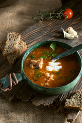 Soup with tomatoes and meat. Food with bread and garlic.